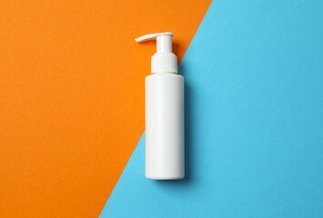 Sunscreen bottle on two-tone surface, top view