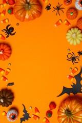 Vertical Halloween decorations arranged on orange background with decorative orange pumpkins, black...