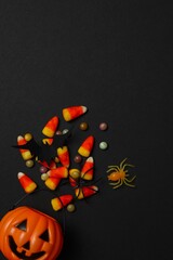 Halloween festive background design with pumpkin basket, candies and spiders. Happy Halloween...