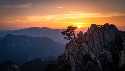 Wide cinematic shot of sharp, rocky cliffs in a mountain range during dusk. Sky is painted with deep oranges and purples.