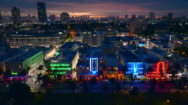 Aerial view of brightly lit buildings along Ocean Drive, with a twilight sky creating a stunning contrast against the vibrant art deco lights, Miami Beach, Florida, United States.