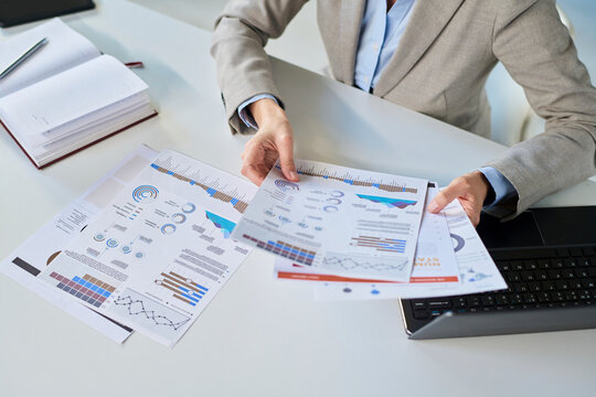 Business manager analyzing financial documents at office desk