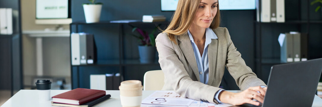 Professional working at laptop in modern office space