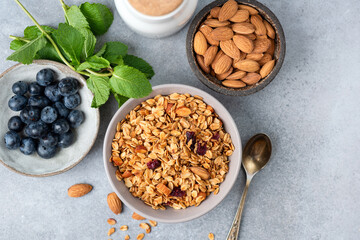 Top view of homemade crunchy oat granola with dried cranberries, almonds. Copy space. Ingredients. Healthy diet food
