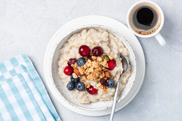 Breakfast oatmeal porridge bowl with berries plus cup of black coffee