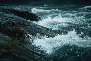 Fototapeta premium Zoomed in view of turbulent rapids in a dark clear river with splashes and foam