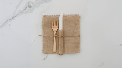 Rustic table setting with wooden cutlery on burlap