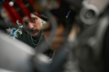 Mechanic repairing vehicle in workshop with focused expression