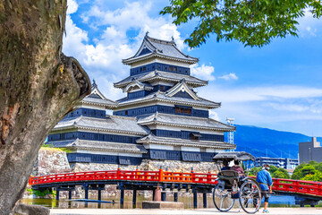Matsumoto Castle or Crow Castle and the red bridge in summer is one of Japanese premier historic castles in Honshu. Landmark and popular for tourists attraction in Matsumoto city, Japan
