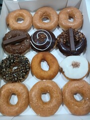 Photo of chocolate donuts, glazed donuts and many other donut flavors.
