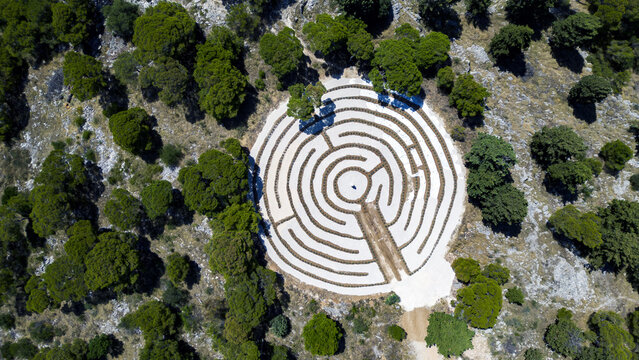 Aerial view of a labyrinth nestled among the trees, a circular puzzle of white and earth tones contrasting with the surrounding greenery, Rogoznica, &Aring;&nbsp;ibensko-kninska &Aring;&frac34;upanija, Croatia.