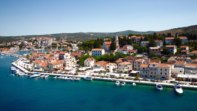 Aerial view of terracotta rooftops cascading towards the turquoise coastline, where boats bob gently in the sun-drenched marina, Rogoznica, &Aring;&nbsp;ibensko-kninska &Aring;&frac34;upanija, Croatia.