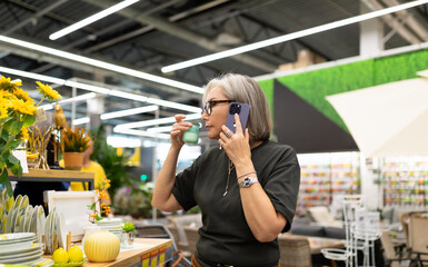 Modern commercial photoshoot in a construction hypermarket featuring a middle-aged woman exploring...