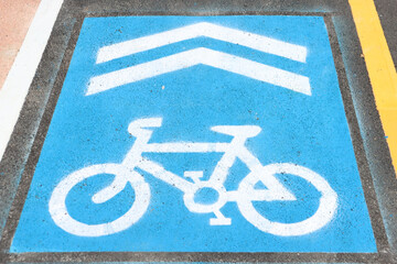 Blue Bicycle Lane Sign with Arrows Painted on The Road