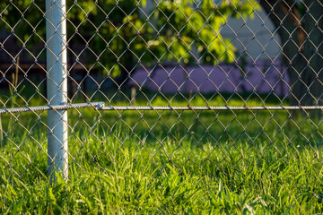 A chain-wire fence and green grass. Wire netting, wire-mesh fence, chain-link fence, cyclone fence, hurricane fence, or diamond-mesh fence) is a type of woven fence