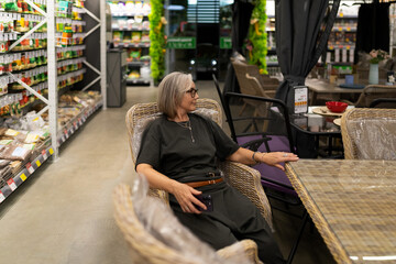 Woman shop at a large home improvement store exploring various departments for household and...