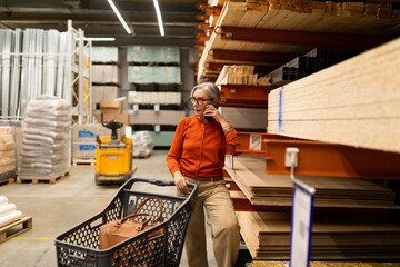 Woman shopping for home improvement supplies in a large hardware store with various departments