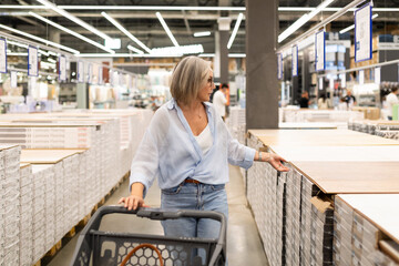 Fototapeta premium Engaging in shopping activities at a modern home improvement store with a middle-aged woman exploring various departments