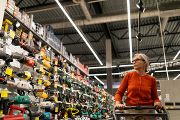 Shopping experience captured as a woman browses tools and home goods in a hypermarket