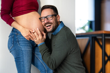 Man in love hugs his pregnant wife, they are waiting together for the baby's arrival. Love, family