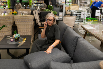 Middle-aged woman shopping in a home improvement store exploring furniture and home d cor