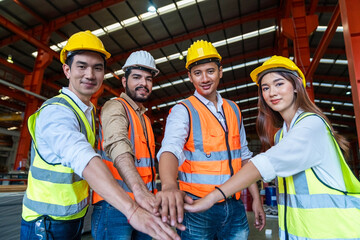 Engineers team in protective helmets and vests standing Metal Sheet machines in factory.  Industrial successful and teamwork concept