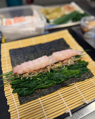 Shrimp sushi roll prepared with fresh greens.