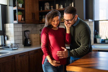 Tender moment, husband lovingly embraces his pregnant wife's belly while they spending time together