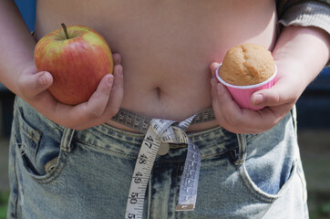a girl holding an apple in one hand and a cake in the other, a weight loss concept