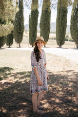 Tourist enjoying summer holidays in tuscany countryside near cypresses