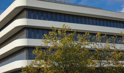 A beautiful new corporate building with a modern design, many windows, and a white facade near Geneva, Switzerland