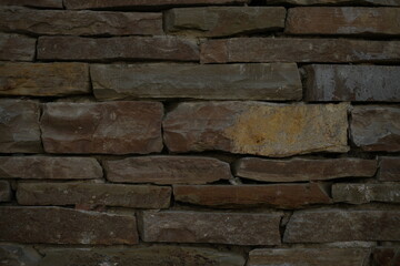 texture of a natural stacked stone wall. The image shows uneven, layered stones with rough surfaces and earthy brown tones. Perfect for backgrounds, architectural themes, construction materials, rusti
