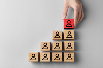 Dismissal. Woman taking red cube with human icon among others on white background, top view