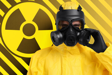 Man wearing hazmat suit and gas mask against radioactive sign