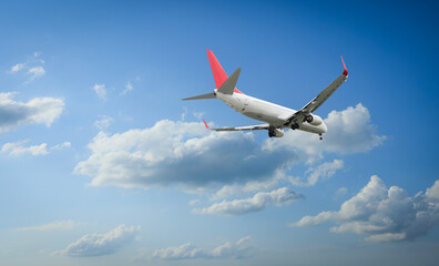 Airplane flying in beautiful blue sky with clouds