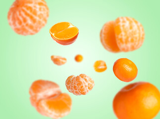 Juicy tangerines swirling in air against aquamarine color background
