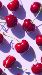 A vibrant and fresh display of ripe red cherries on a soft pink background, casting interesting shadows. The composition highlights the cherries' glossy texture and rich color