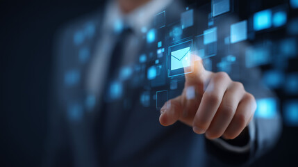 Businessman touches glowing email icon on digital screen