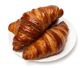Three freshly baked classic delicious fresh organic croissants on white ceramic plate isolated on...