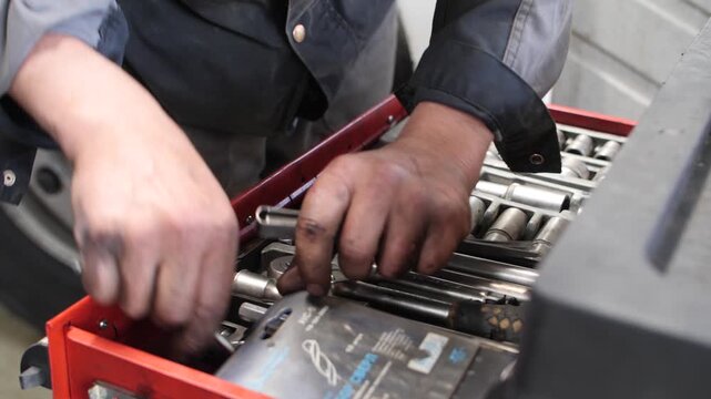 Mechanic man searching tools in toolbox in professional service center.