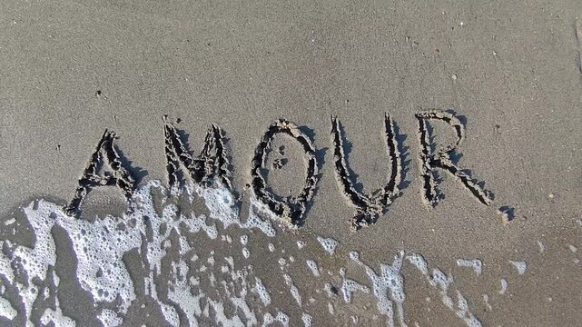 Le mot "Amour" &eacute;crit dans le sable et happ&eacute; par les vagues