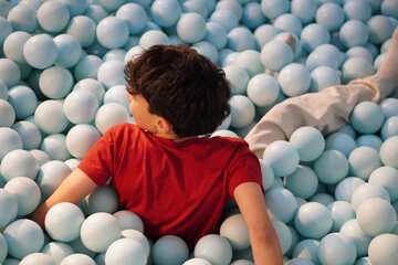 Happy Teenage Boy on His Back in Ball Pool