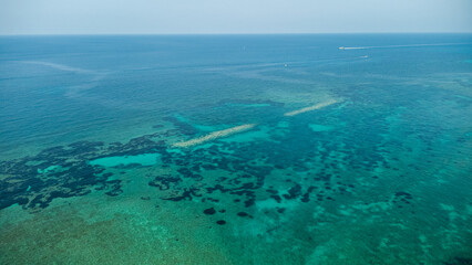 Calabrian Reefs Beneath the Surface – Aerial View of Turquoise Waters and Distant Boat Wake