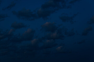 A large, dark cloud floats in a deep twilight sky, tinted with faint pink light, creating a minimalist, moody scene with ample space for text.