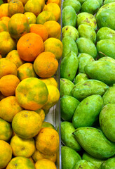Ripe orange and mango side by side under the light