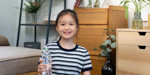 Wellness. Happy girl holding a water bottle and smiling.