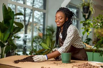 Florist putting soil into the flower pot while planting the flowers