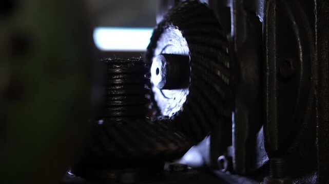 Industrial metal rolling machine shaping threaded rod in metallurgy workshop.