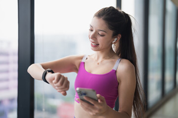 Young Hispanic Gen Z Woman in Sportswear Checking Smartwatch Health App After Gym Workout