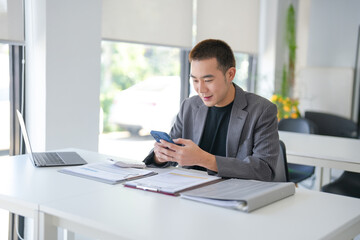 Naklejka premium Asian Businessman with Smartphone&nbsp;working mobile devices cell telephone technology e-commerce smartphone business professional investor working new start up project